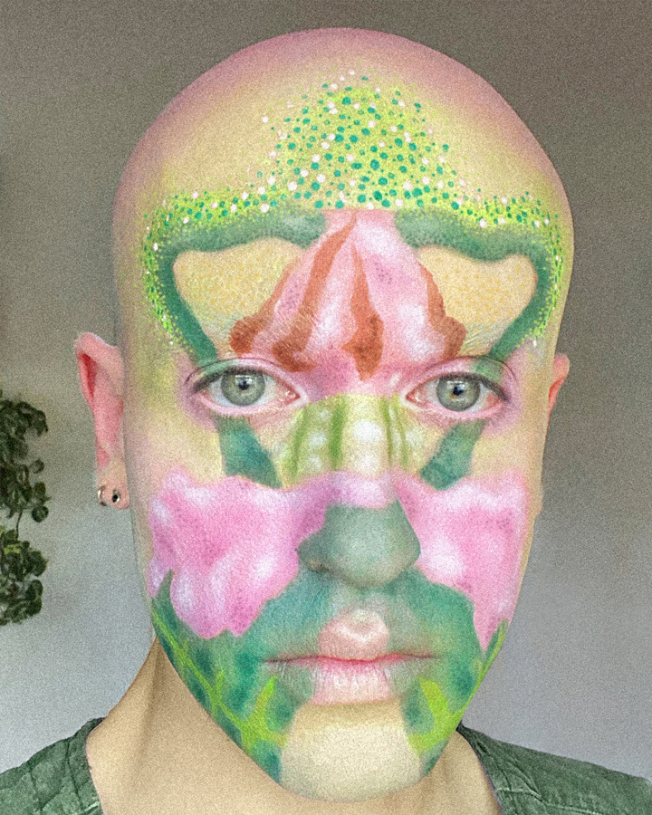 Close up portrait of Jesse Clark with artistic facepaint of a colorful fire poppy flower